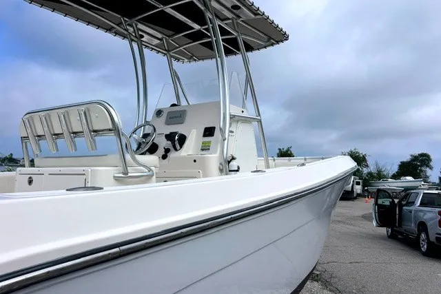 Slide: The Image of 2020 Cobia 237 Center Console boat with sleek design, parked outdoors under cloudy sky. - 2