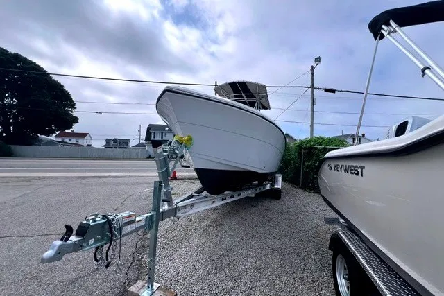 Slide: The Image of 2020 Cobia 237 Center Console boat on trailer, parked outdoors under cloudy sky. - 3