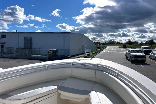 Slide: The Image of 2020 Cobia 237 Center Console boat parked near industrial building under blue sky. - 9