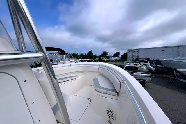 Slide: The Image of 2020 Cobia 237 Center Console boat with spacious seating, docked under a cloudy sky. - 6