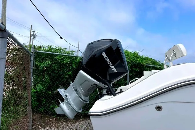 Slide: The Image of 2020 Cobia 237 Center Console with Mercury outboard motor, parked near a fence. - 11