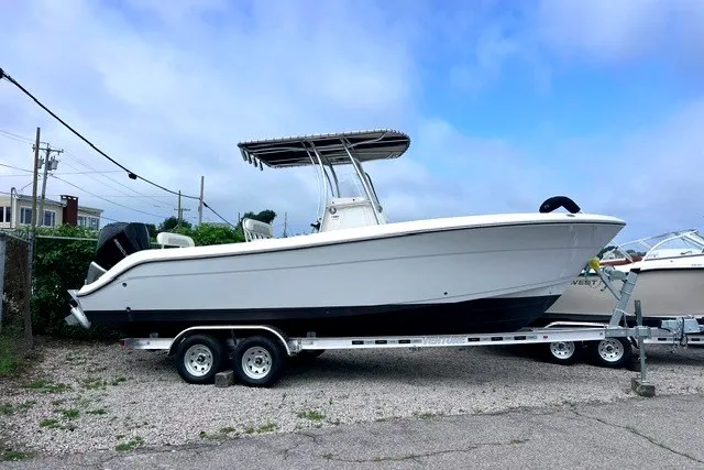 Slide: The Image of 2020 Cobia 237 Center Console boat on trailer, parked outdoors under cloudy sky. - 5