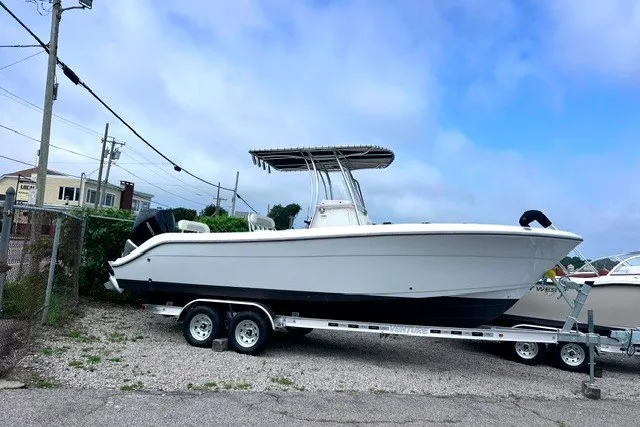 The Image of 2020 Cobia 237 Center Console boat on trailer, parked outdoors under a cloudy sky. - 0