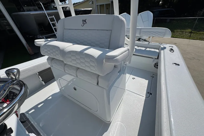 Slide: The Image of 2027 Yellowfin 26 Hybrid boat interior with white cushioned seating and steering wheel. - 28