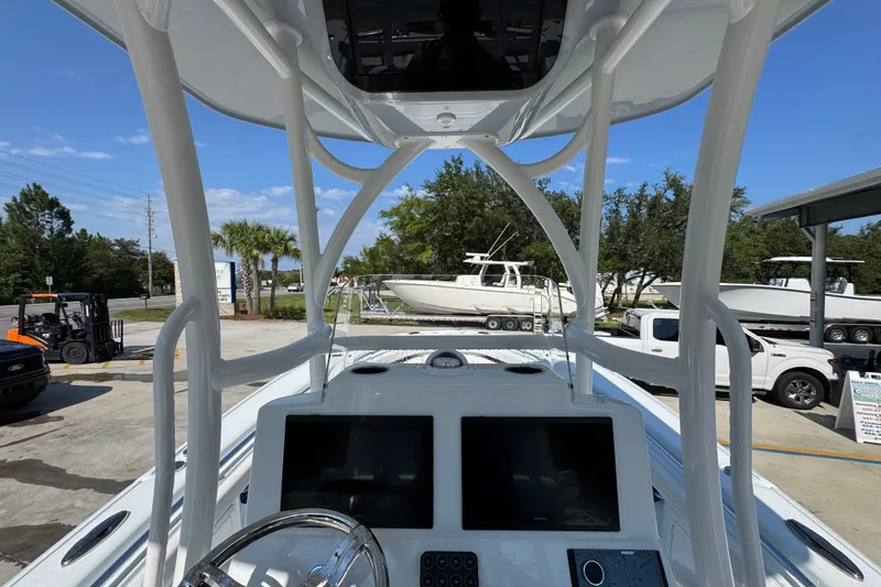 Slide: The Image of 2027 Yellowfin 26 Hybrid boat dashboard with dual screens, parked outdoors. - 34