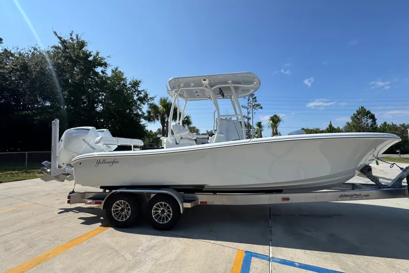 Slide: The Image of 2027 Yellowfin 26 Hybrid boat on trailer, parked outdoors under clear sky. - 10