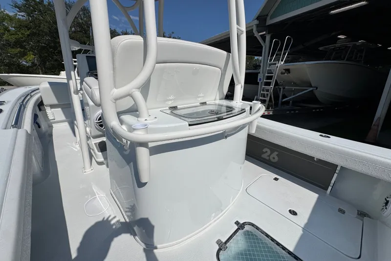 Slide: The Image of 2027 Yellowfin 26 Hybrid boat interior with console and seating, docked under a shelter. - 36