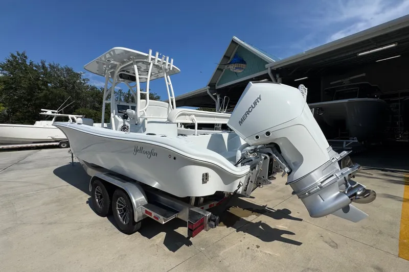 Slide: The Image of 2027 Yellowfin 26 Hybrid boat with Mercury engine on trailer, parked outdoors. - 16