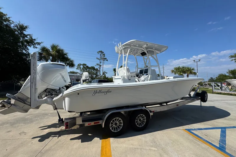 Slide: The Image of 2027 Yellowfin 26 Hybrid boat on trailer, parked outdoors under clear sky. - 11