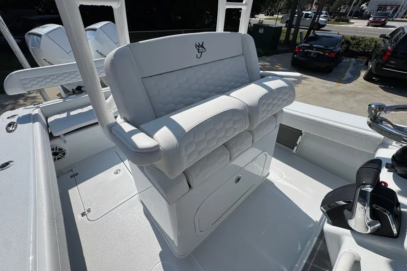Slide: The Image of 2027 Yellowfin 26 Hybrid boat interior with white cushioned seating and control panel. - 31