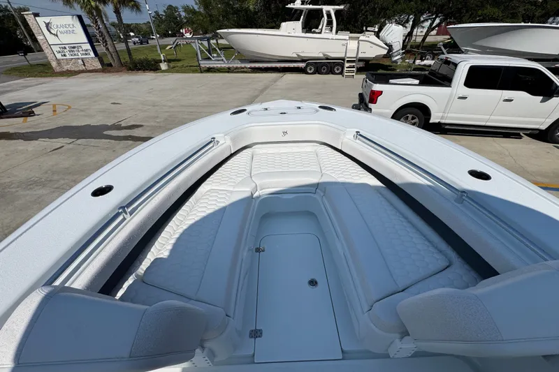 Slide: The Image of 2027 Yellowfin 26 Hybrid boat interior with white cushioned seating and storage compartments. - 19