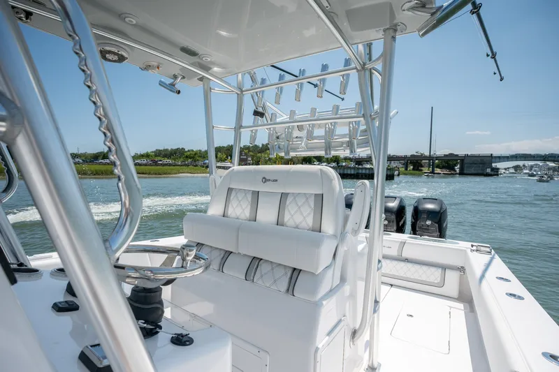 Slide: The Image of 2022 Sea-Lion 34 TE boat interior with helm, rod holders, and outboard motors on a sunny day. - 24