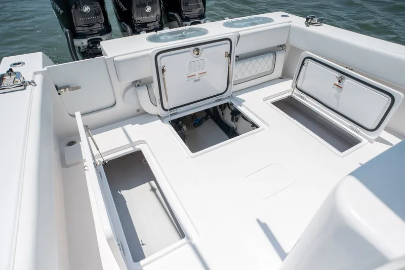 Slide: The Image of 2022 Sea-Lion 34 TE boat deck with open storage compartments and powerful outboard engines. - 36