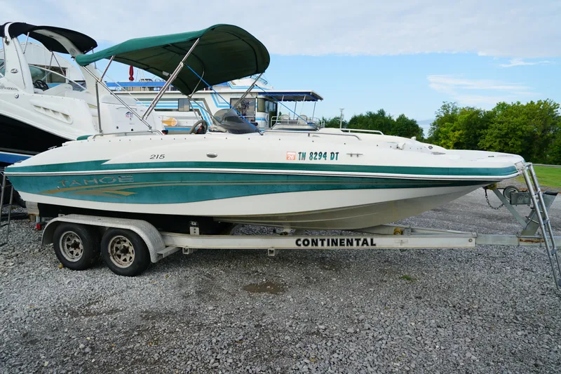 Slide: The Image of 2007 Tahoe 215 I/O boat on trailer, parked outdoors, with green canopy. - 10