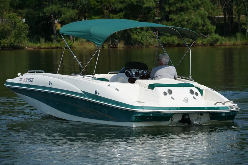Slide: The Image of 2007 Tahoe 215 I/O boat cruising on a calm lake with green canopy. - 7