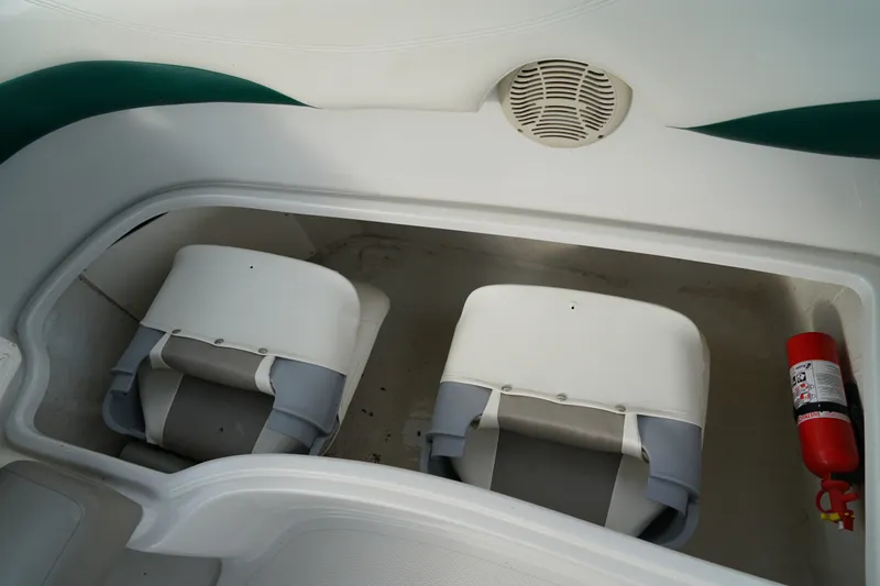 Slide: The Image of 2007 Tahoe 215 I/O boat storage compartment with seats and fire extinguisher. - 24