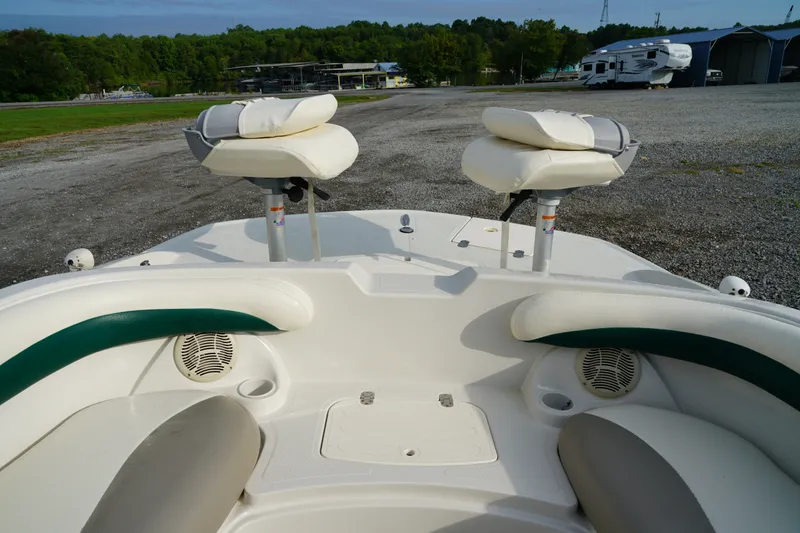 Slide: The Image of 2007 Tahoe 215 I/O boat interior with seating and speakers, parked outdoors. - 23