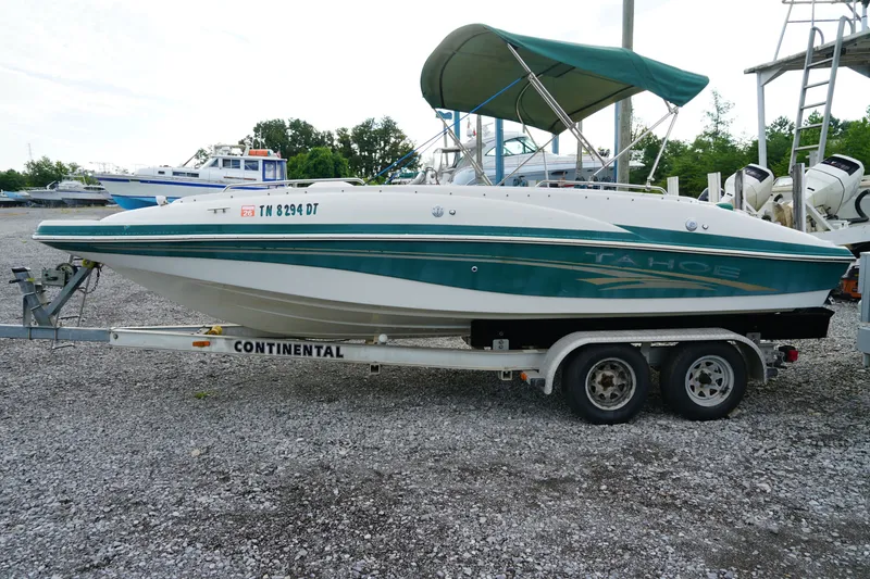 Slide: The Image of 2007 Tahoe 215 I/O boat on trailer, green and white, parked on gravel lot. - 12