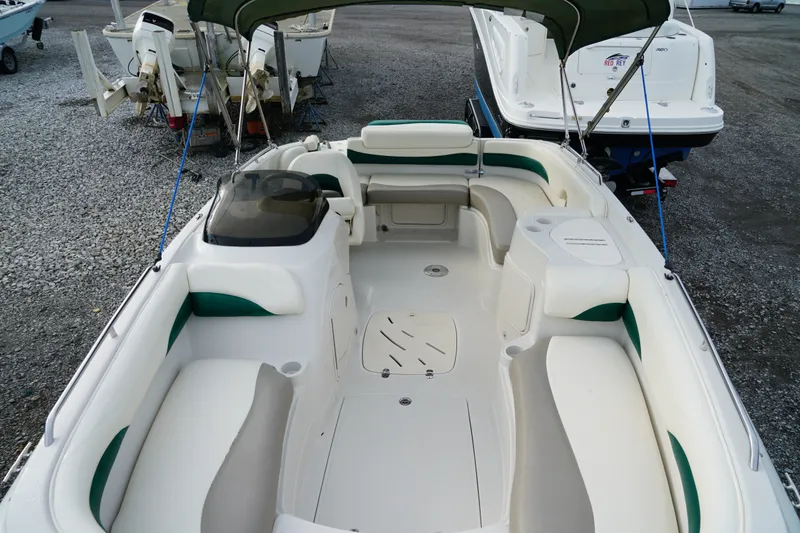 Slide: The Image of 2007 Tahoe 215 I/O boat interior with seating and canopy, parked on gravel. - 21