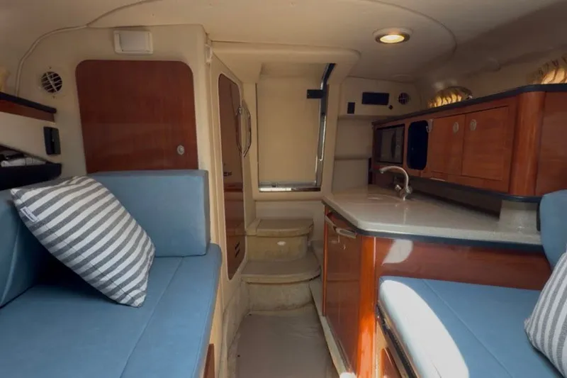 Slide: The Image of Interior of 2006 Sea Ray 270 Amberjack boat with cozy seating and kitchenette. - 23