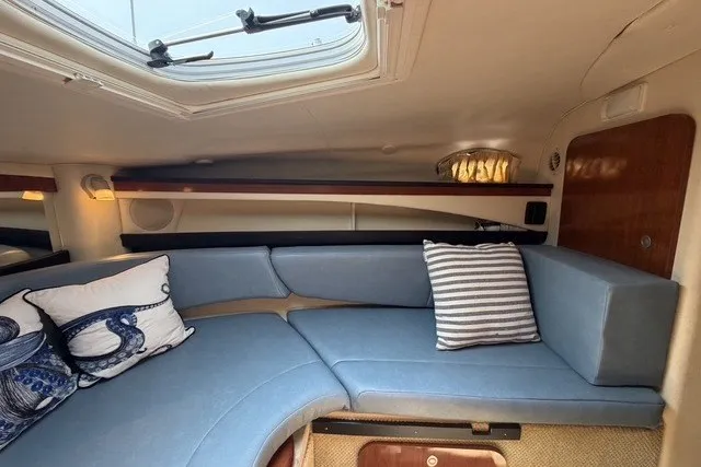 Slide: The Image of Interior of 2006 Sea Ray 270 Amberjack with blue seating and nautical-themed pillows. - 24