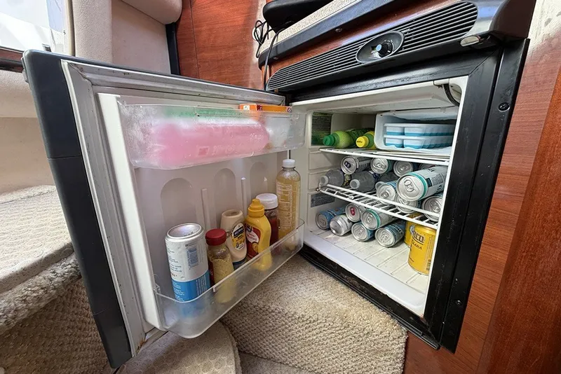 Slide: The Image of Open mini fridge on 2006 Sea Ray 270 Amberjack, stocked with drinks and condiments. - 18