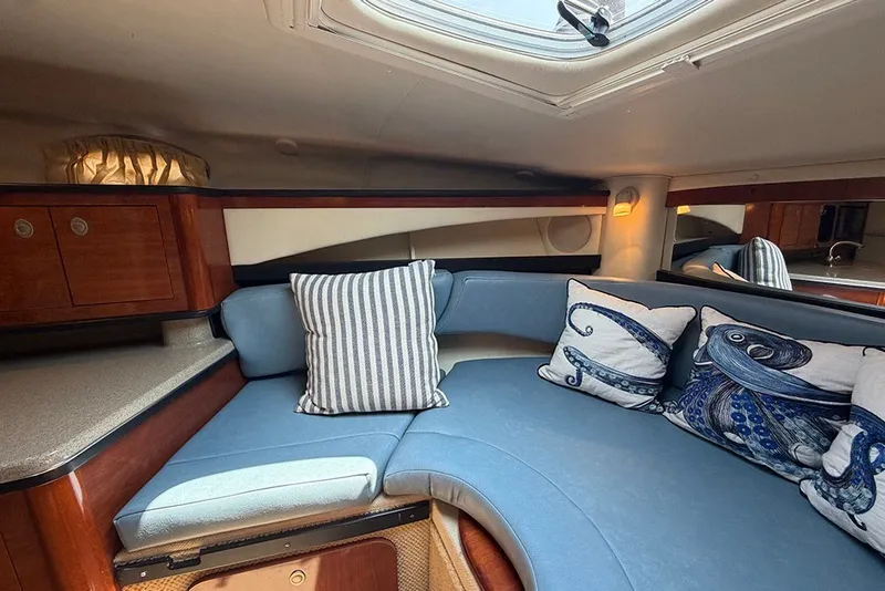 Slide: The Image of Interior of 2006 Sea Ray 270 Amberjack with blue seating and nautical-themed pillows. - 25