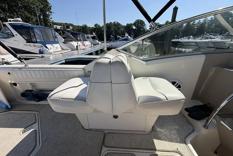 Slide: The Image of 2006 Sea Ray 270 Amberjack boat interior with white seating at marina. - 11