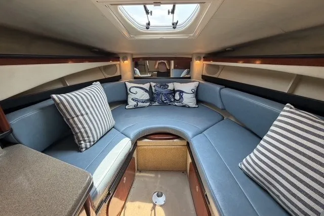 Slide: The Image of Interior of 2006 Sea Ray 270 Amberjack with blue seating and nautical-themed pillows. - 20