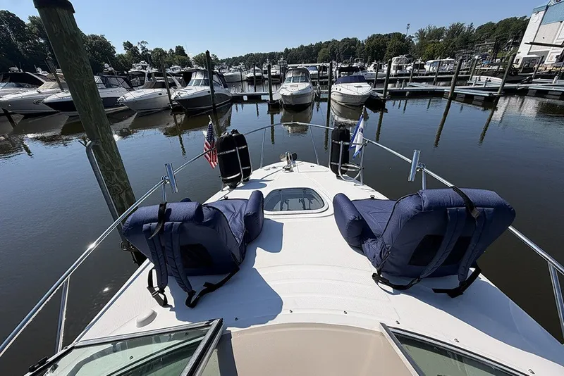Slide: The Image of 2006 Sea Ray 270 Amberjack boat docked in a marina with cushioned seating. - 13