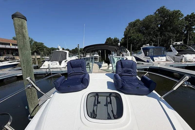 Slide: The Image of 2006 Sea Ray 270 Amberjack boat with blue chairs docked at marina. - 14