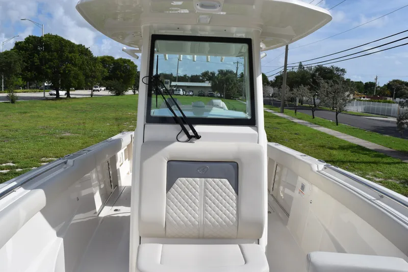 Slide: The Image of 2027 Sailfish 272 CC boat interior with seating and windshield, parked on grassy area. - 13