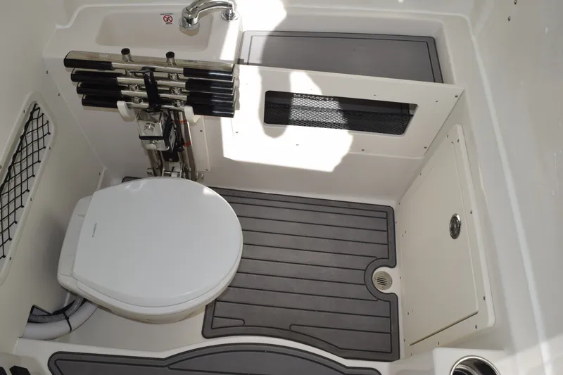 Slide: The Image of 2027 Sailfish 272 CC boat interior with toilet, sink, and rod holders. - 18