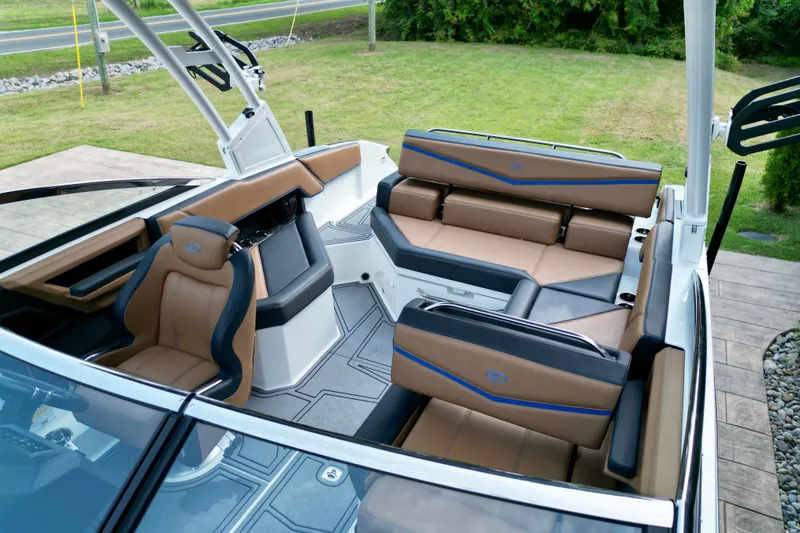 Slide: The Image of 2022 Cobalt R4 Surf boat interior with luxurious tan and black seating. - 11