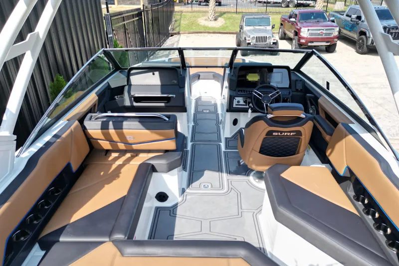 Slide: The Image of 2022 Cobalt R4 Surf boat interior with tan seating and modern dashboard design. - 9