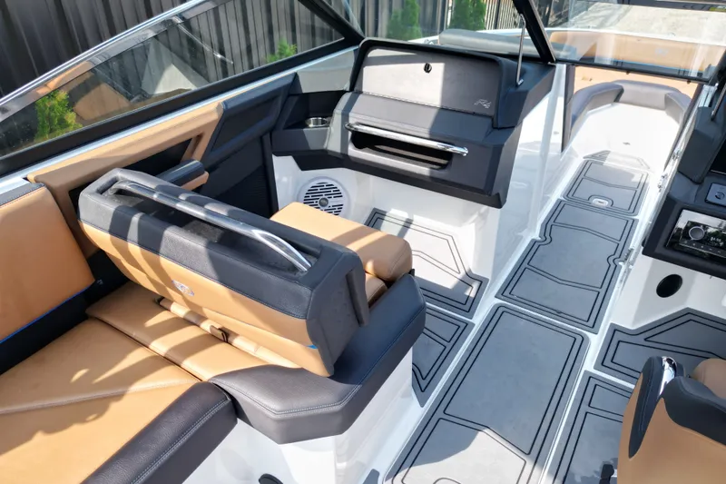 Slide: The Image of 2022 Cobalt R4 Surf boat interior with tan and black seating, modern dashboard, and sleek design. - 15