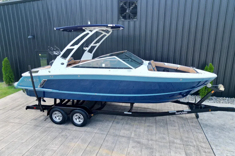 Slide: The Image of 2022 Cobalt R4 Surf boat on trailer, blue and white design, parked outdoors. - 7