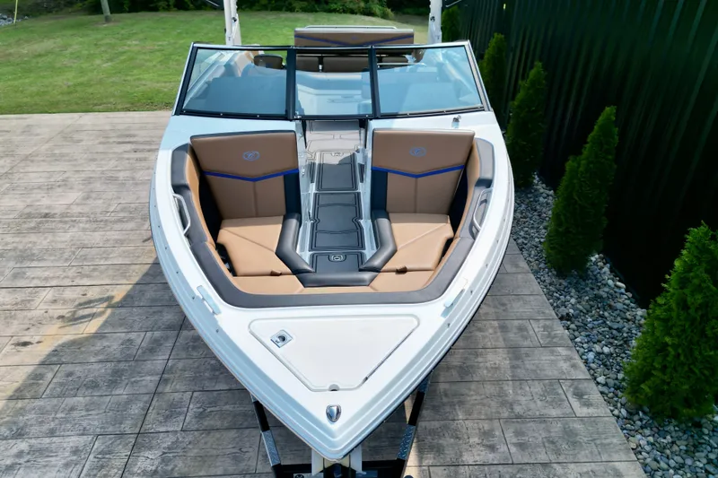 Slide: The Image of 2022 Cobalt R4 Surf boat with tan seating, docked on a wooden platform. - 13