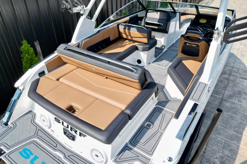 Slide: The Image of 2022 Cobalt R4 Surf boat interior with tan and black seating, sleek design. - 10