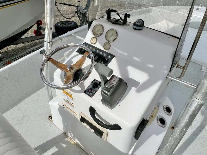 Slide: The Image of The image shows the helm of a 2009 Pro-Line Pro-Lite 17 CC boat with a steering wheel and gauges. - 19