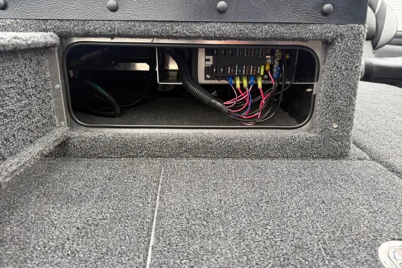 Slide: The Image of Interior wiring of 2027 Lund 1975 Pro-V boat, showcasing electrical components and carpeted finish. - 16