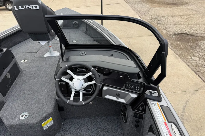 Slide: The Image of Interior view of 2027 Lund 1975 Pro-V boat, featuring steering wheel and dashboard controls. - 22