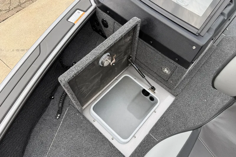 Slide: The Image of Open storage compartment in a 2027 Lund 1975 Pro-V boat, featuring carpeted interior. - 15