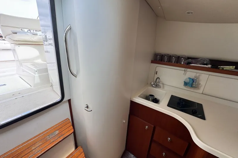 Slide: The Image of 1999 Tiara Yachts 2900 Open interior with kitchenette, sink, and stove. - 28