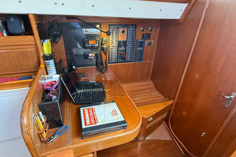 Slide: The Image of Navigation station of 1988 Belliure 41 yacht with control panel, laptop, and Yanmar manual. - 24