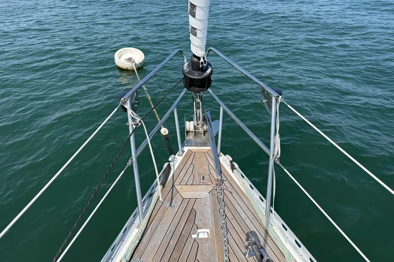Slide: The Image of Bow of 1988 Belliure 41 sailboat with wooden deck, anchored in calm waters. - 62