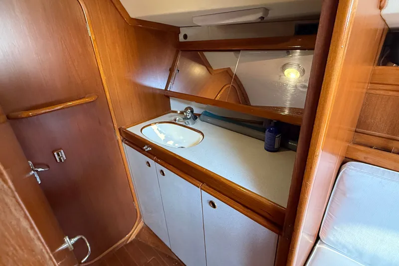 Slide: The Image of Interior of 1988 Belliure 41 yacht featuring a wooden bathroom with sink and mirror. - 44