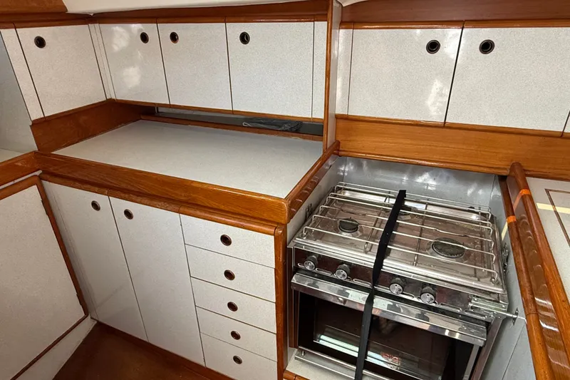 Slide: The Image of 1988 Belliure 41 yacht kitchen with stove, wooden cabinets, and ample storage space. - 34