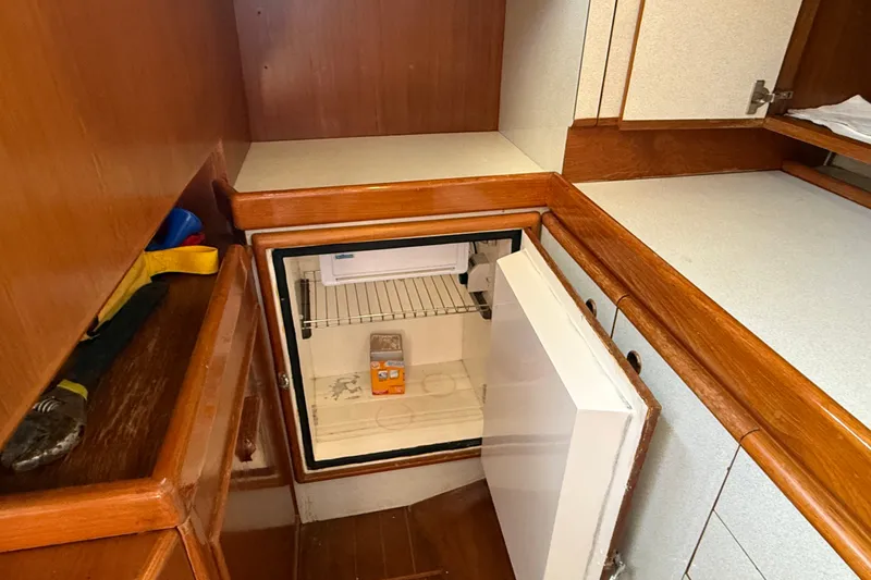 Slide: The Image of 1988 Belliure 41 yacht interior with open mini fridge in wooden cabinetry. - 38