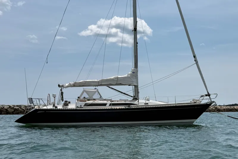 The Image of 1988 Belliure 41 sailboat on calm water, clear sky background. - 0
